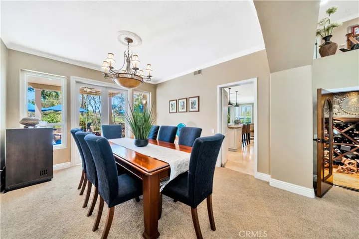 Formal Dining Room With Double Doors Out to Lush Backyard & Pool