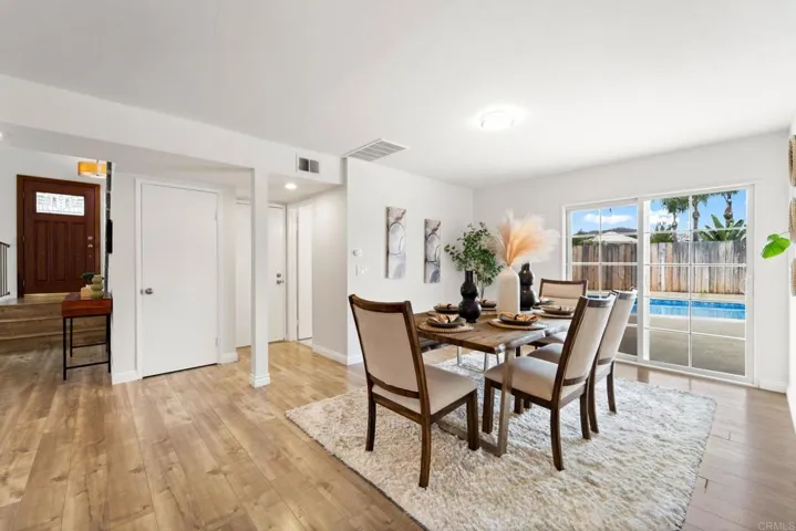 A dining area with a view of the pool offers a delightful setting for enjoying meals & entertaining.