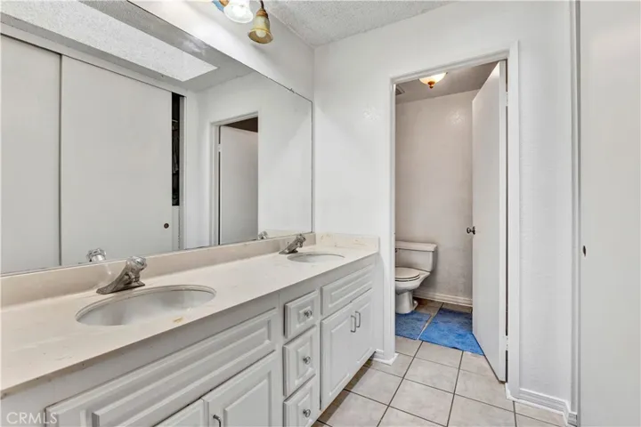 Primary Suite Bathroom with Dual Sinks & Tile Floor
