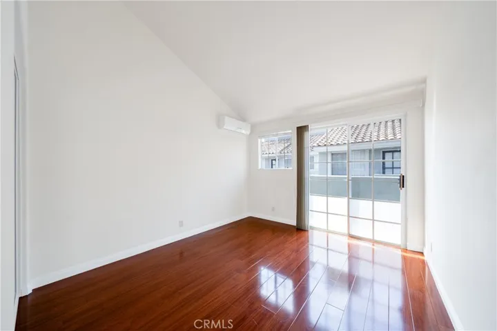 Guest bedroom 2, with shared balcony and AC wall unit.