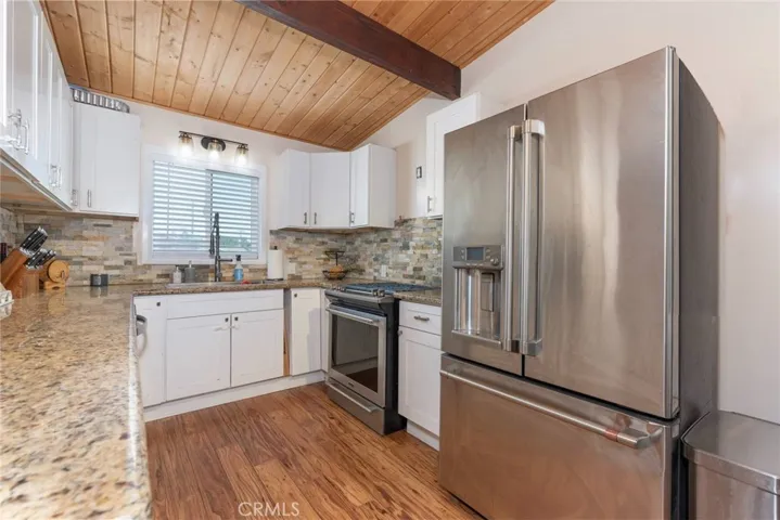 Kitchen with stainless steel appliances and granite counters. Refrigerator not included in sale.