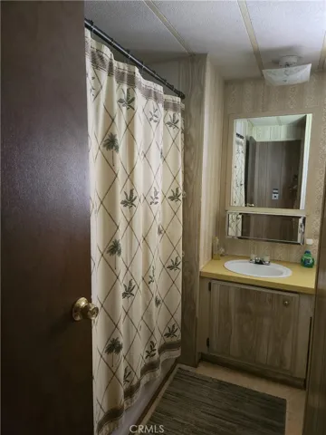 Hall Bathroom with tub/shower unit and sit-down vanity ands sink.