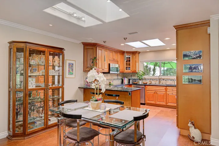 Detailed view of the dining area with the kitchen in the background. Note the two skylights. There are also skylights in each bathroom.