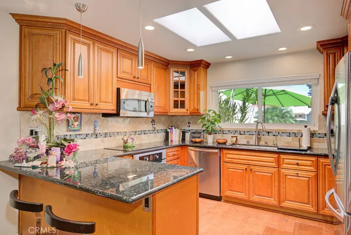 Gorgeous kitchen features custom maple cabinetry with ample storage capacity. The attractive backsplash is highlighted with elegant glass accents. Additional features include granite countertops, stainless steel appliances, lazy susan and a breakfast bar that seats two.