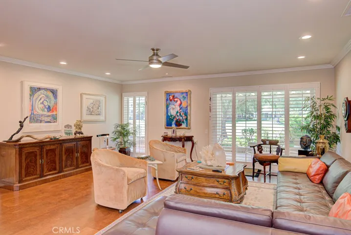 Another view of the living room. Among the many bonus features of this remodeled home are smooth ceilings, recessed lighting, ceiling fans, crown molding and baseboards, dual-pane windows and plantation shutters.
