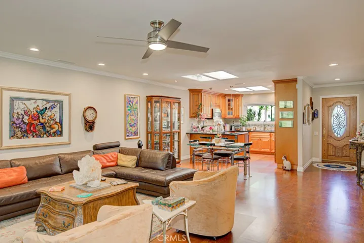 Another view of the living room. Dining area and kitchen are in the background. Front door can be seen at right.