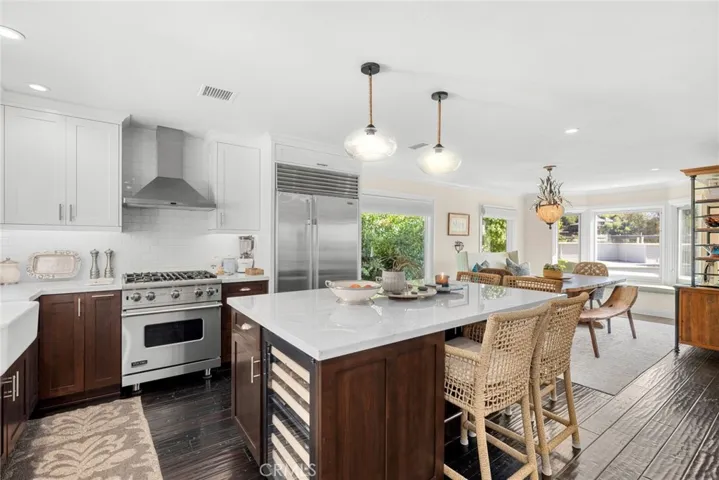 Custom Shaker cabinetry complements an island and top-tier appliances that include a drawer microwave, built-in Sub-Zero refrigerator, an under-cabinet U-Line wine refrigerator, and a Viking range.