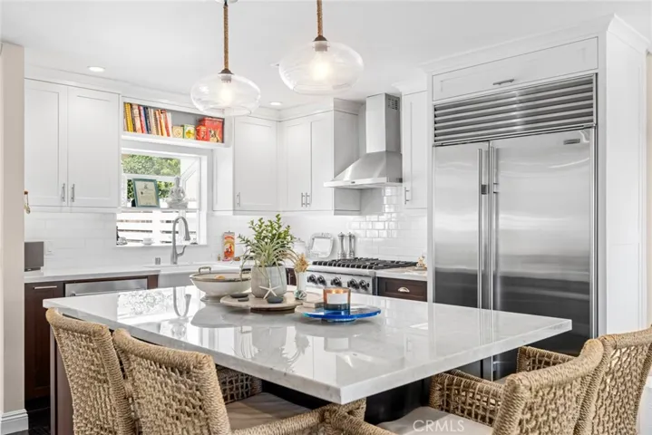 From mealtime to party time, the updated kitchen shines with marble countertops, a garden window, and a farmhouse sink.