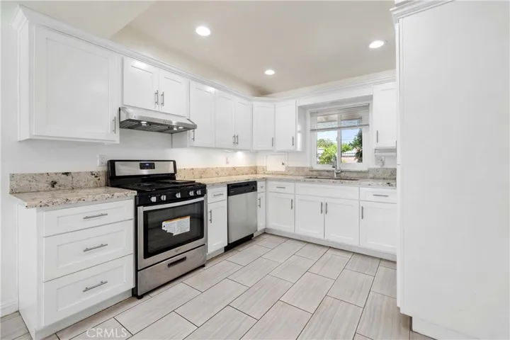 Kitchen with tile floor, shaker cabinets & granite countertops