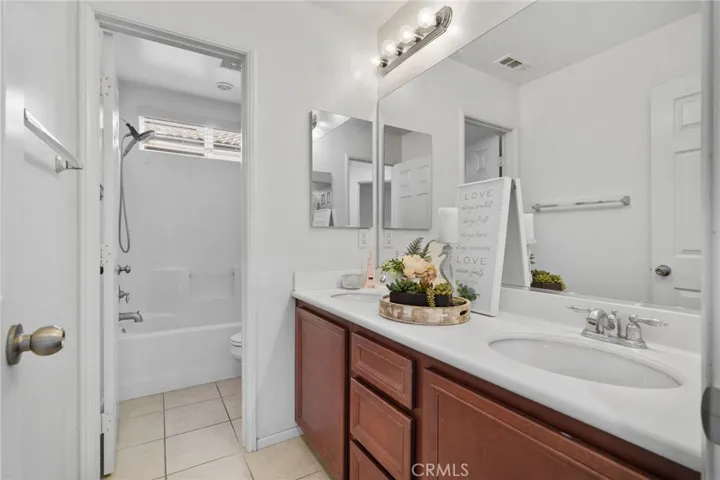 Second upstairs full bathroom with dual sinks.