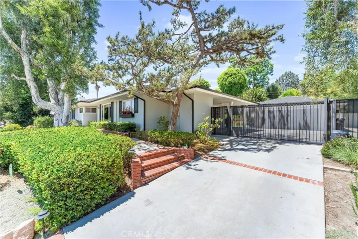 Enter bricked pathway, past mature Bonsai tree & cheerful window planters to arrive at the front porch.
Remote controlled driveway gate opens to access garage.