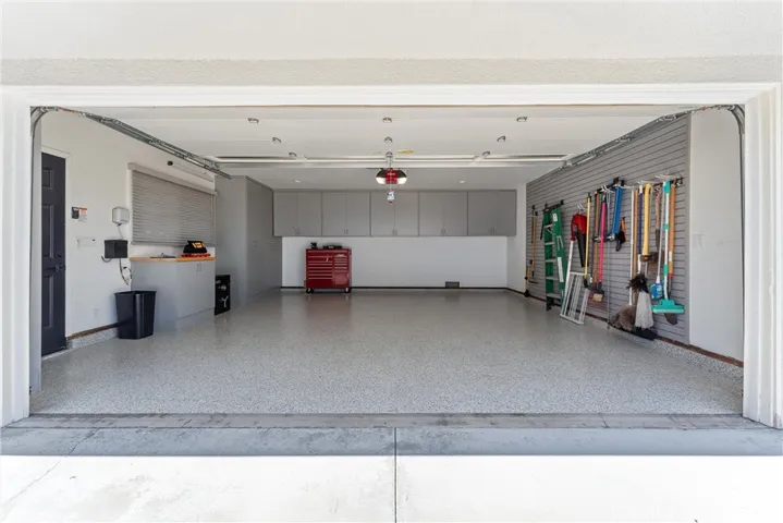 Epoxy garage floors, to park your cars on. Plenty of storage space, floor to ceiling cabinetry and an entire wall dedicated to organization. Access door to garage, window with shades and a built in safe.