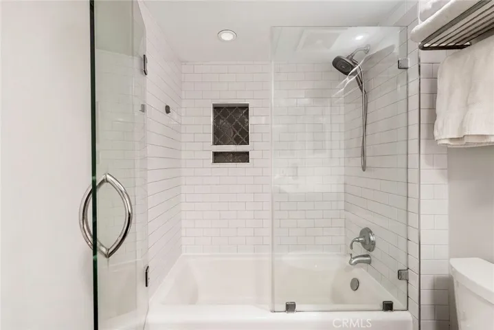 Hall bathroom tub and shower with seamless glass enclosure.