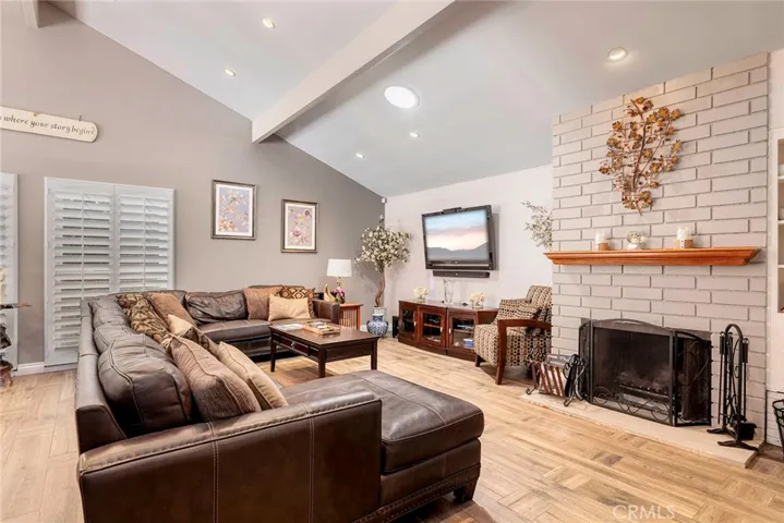 Living room with vaulted ceiling and recessed lighting.
