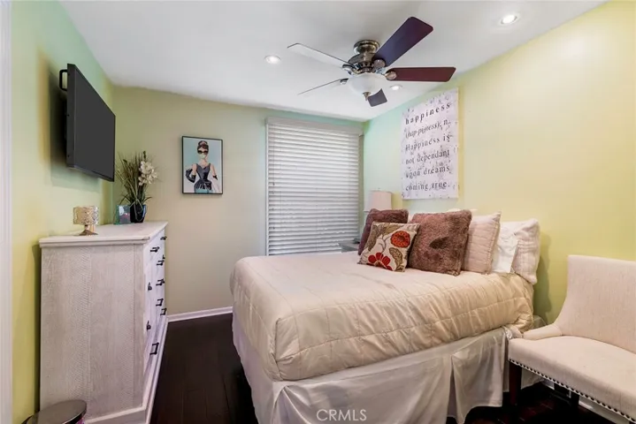 Bedroom 2 with smooth ceiling, ceiling fan and engineered flooring.