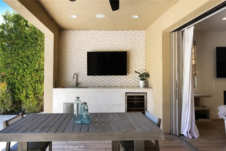 Covered patio space with beverage refrigerator, sink and TV extend your entertaining options