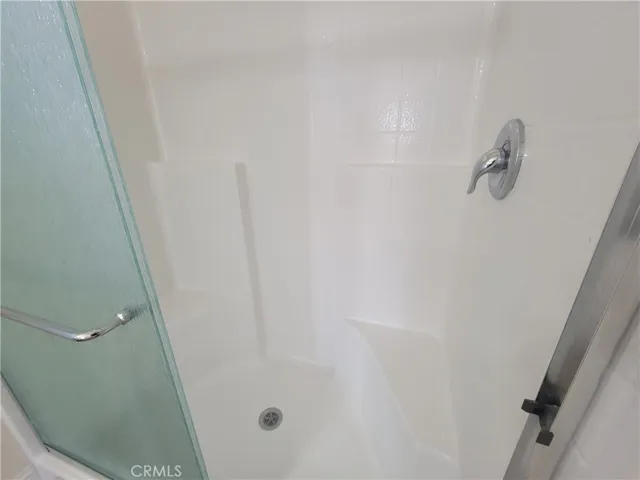 The master walk-in shower complements the two sinks with his 'n' her in-shower built-in seating.