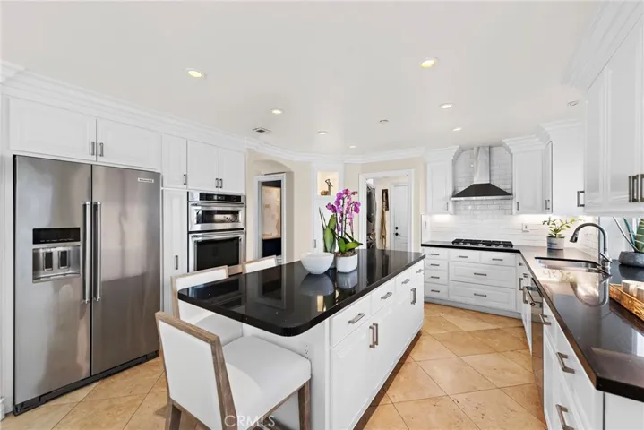 Remodeled Chef's kitchen with quartz countertops, white cabinetry, and stainless steel appliances.