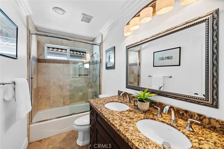Guest bath with dual sinks and shower/tub combination.