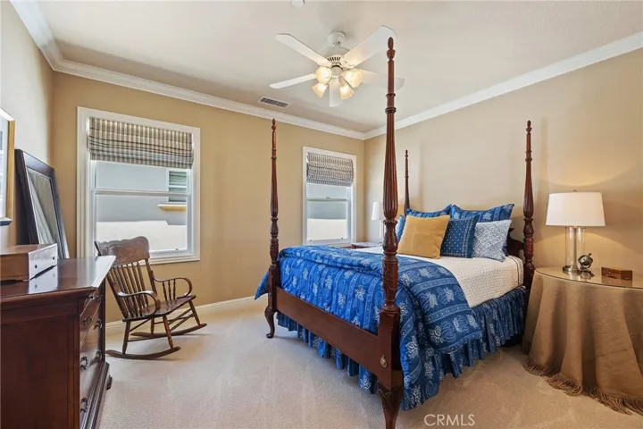 upstairs bedroom with mirrored closet doors and custom window coverings.