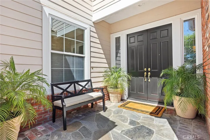 Stone entry, double doors, beveled glass accents.