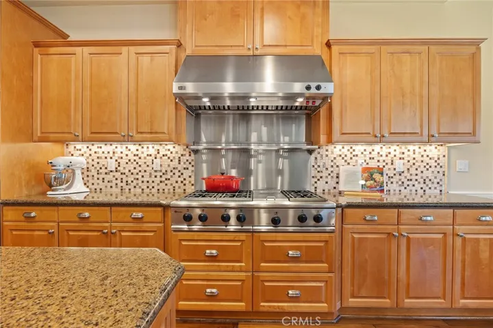 Monogram 6 burner stove with griddle and warming shelf. lots of counter space, custom cabinents and backsplash.