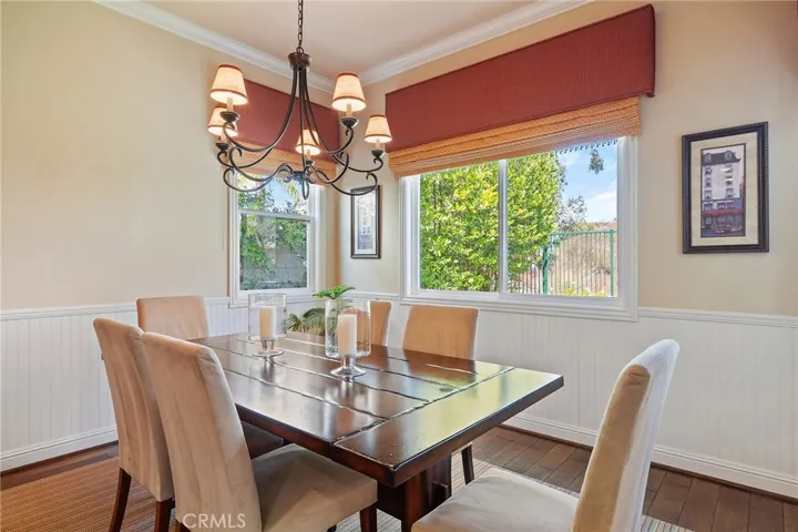 dining in kitchen, wainscoting wall beading, custom window coverings & chandelier.