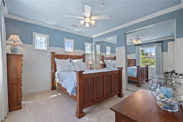 Upstairs bedroom with beveled glass windows, wainscoting, mirrored closet, and full ensuite bathroom.