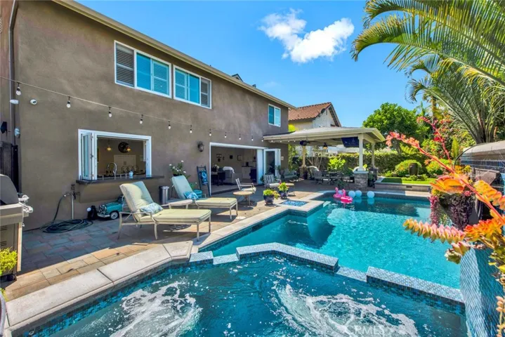 Entertainer's Dream Backyard with Sparkling Saltwater Pool, Spa, Waterfalls, Glass Fire Pit, Lush Tropical Landscaping, Fountain, & Custom-Built California Room, Fully Equipped w/Lighting, Heater, Sun Shades, TV & Speakers