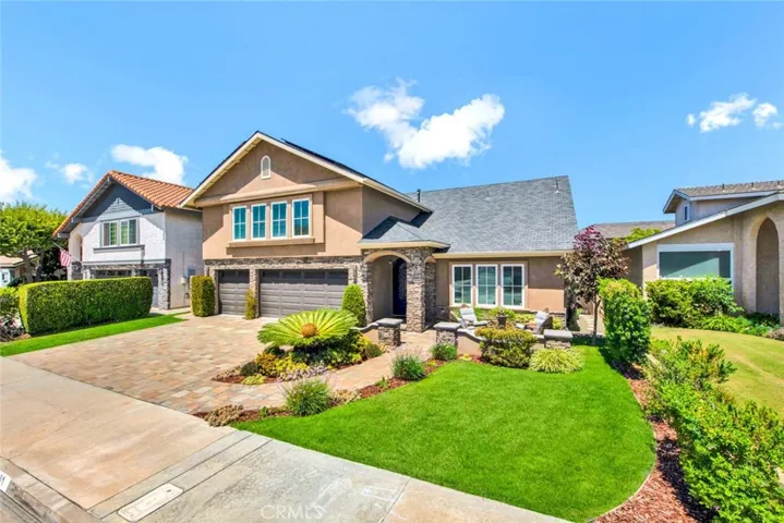 This Impressive Home Stands Out from all the Others with its Captivating Curb Appeal Featuring Stacked Stone Siding & Hardscape, Welcoming Front Patio w/Fountain & Interlocking Paver Driveway
