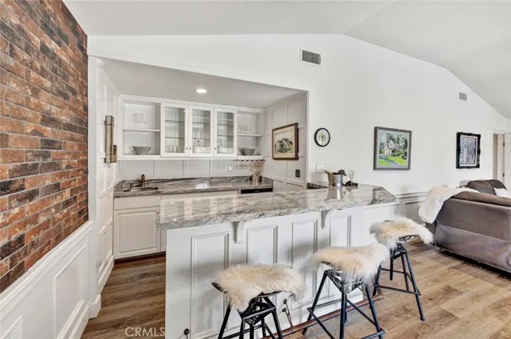 Close Up of the Wet Bar with Seating, Custom Cabinetry and Granite Countertops