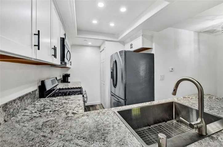Newer stainless steel farmhouse sink and faucet, double door refrigerator included. Lots of storage in kitchen.