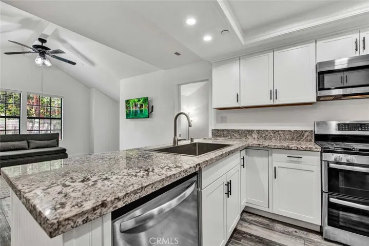 Stainless steel dishwasher and recessed lights in kitchen.