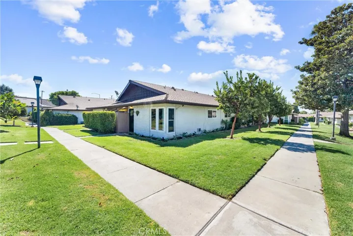 Single level - End Unit surrounded by grass and trees..