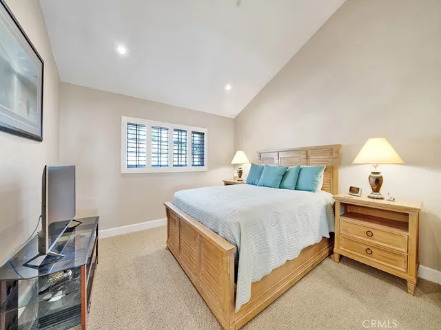 The upstairs guest bedroom features vaulted ceilings as well as an ensuite bathroom and a spacious walk in closet.