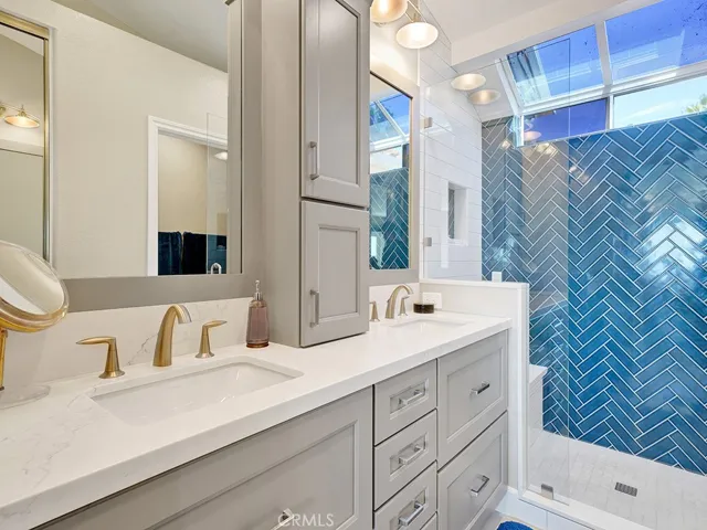 The primary ensuite bathroom has a remodeled Quartz vanity, walk in shower, mirrors, light fixtures, toilet and more.
