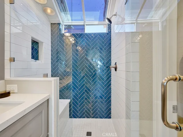 Another view of the beautifully remodeled ensuite primary bathroom showing the gorgeous tiled shower.
