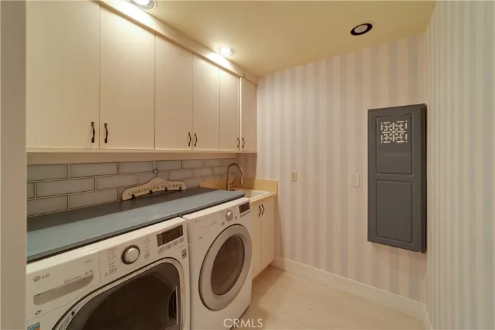 Laundry with a sink, cabinets, and a iron board in the main house.