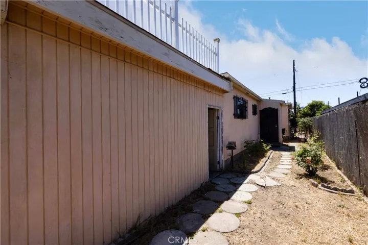 Side of the house. The first door leads into the "workshop" or whatever you would use it for. The black screen door leads you into the house through the laundry room.