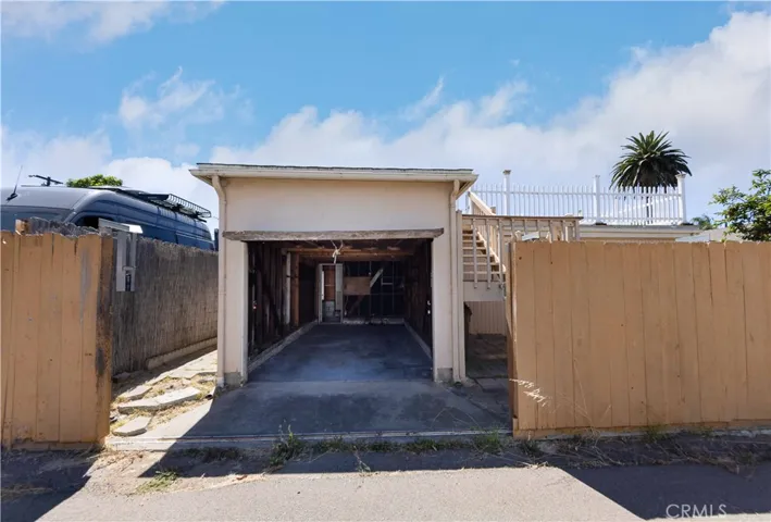 Behind the house. Entrance into the garage from ally behind the property. This has a sliding gate to be able to enter.