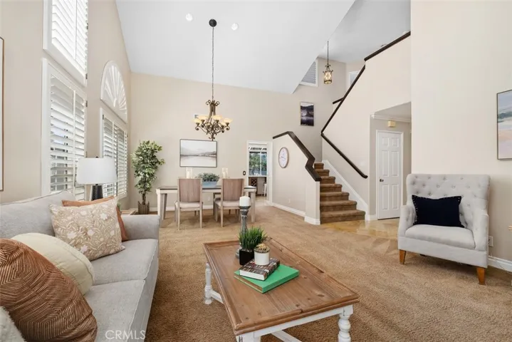 This spacious living and dining area, features high ceilings, plantation shutters, fresh neutral paint, and lots of natural light.
