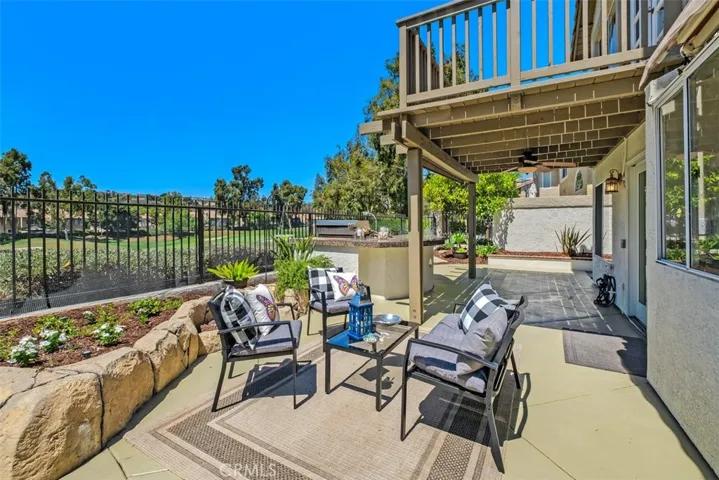 A retractable patio awning, firepit, covered patio and large BBQ island with an  outdoor refrigerator complete this California outdoor living space.