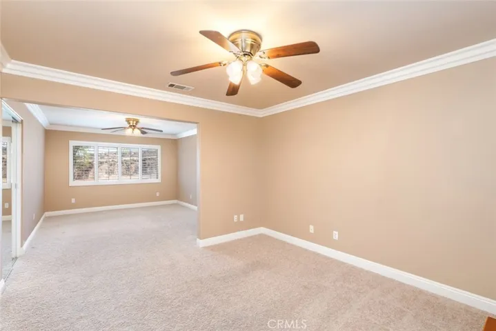 This bedroom is spacious and open, offering plenty of natural light and room for a sitting area.