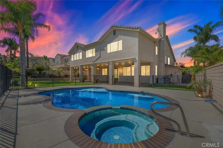 Stunning pool and jacuzzi, surrounded by a security gate for safety