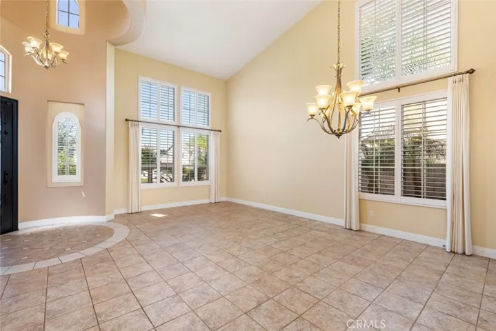 The entry and living room feature high ceilings and large windows for a bright and open atmosphere.