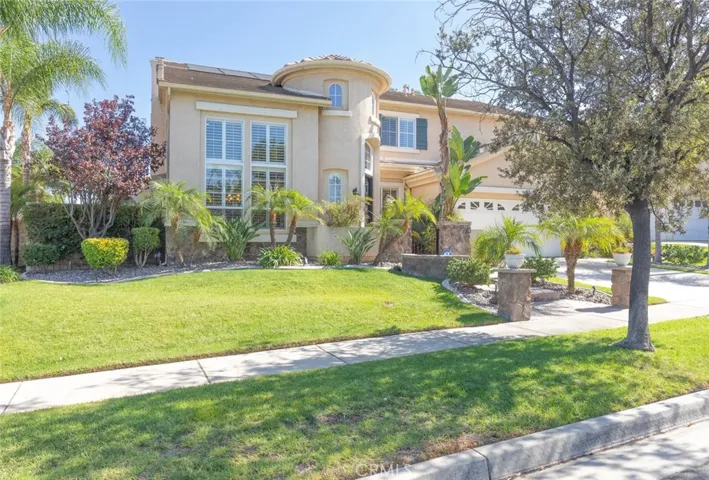 This home features exceptional curb appeal with its lush landscaping, stone accents, and a grand turret-style entrance.