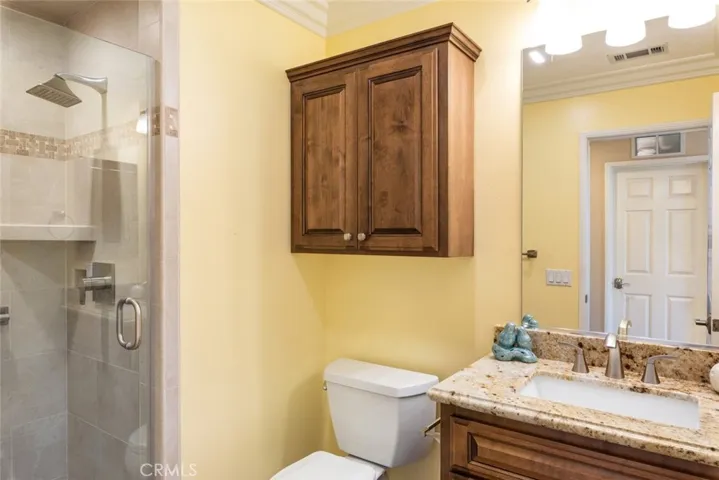 The bathroom offers a convenient walk-in shower with built-in shelving for easy access and storage.
