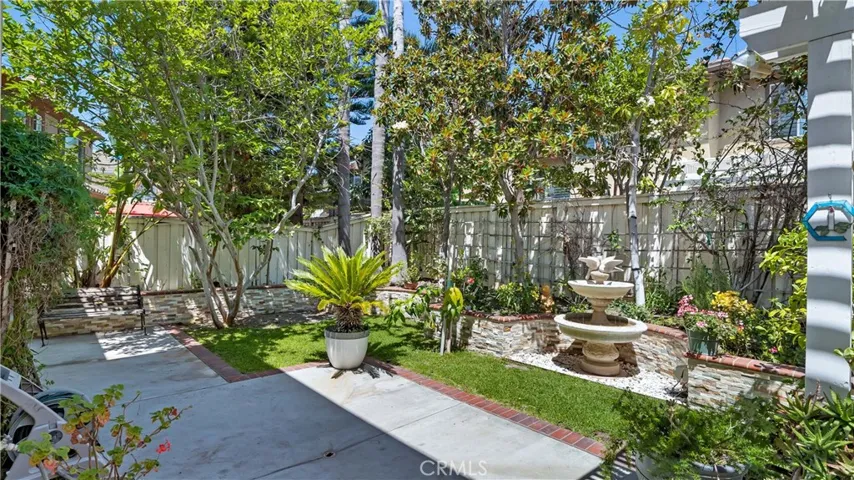 A bubbling fountain and a patio plus great greenery. Love the stacked stone planters.