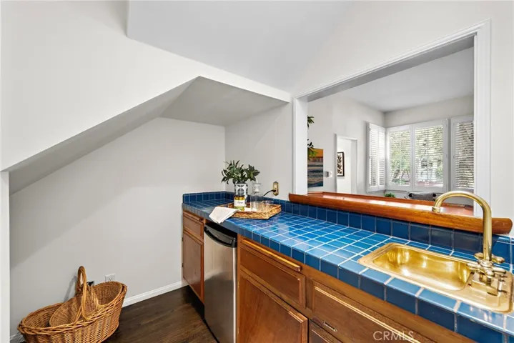Tiled wet bar w/hardwood floors & refrigerator