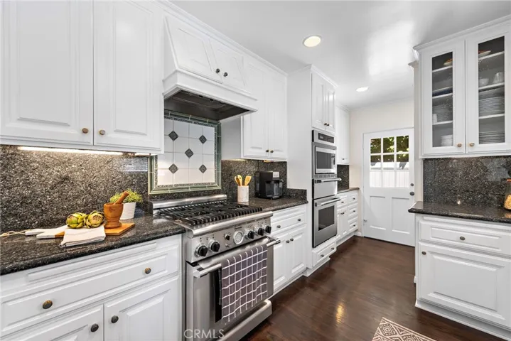 Inlaid tile backsplash custom cabinbets and double ovens